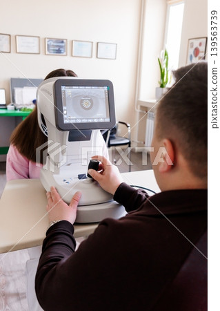 Ophthalmologist examining patient eye with digital slit lamp biomicroscope device in clinic, medical technology concept Ophthalmologist examining patient eye with digital slit lamp biomicroscope device in clinic, medical technology concept 139563739