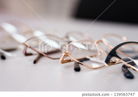 Selective focus row of eyeglasses frames with blurred background Selective focus row of eyeglasses frames with blurred background 139563747