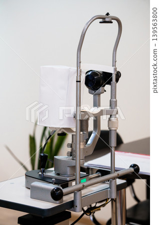 Medical ophthalmology examination equipment and instrument for eye testing in clinical office with gray metal frame on table Medical ophthalmology examination equipment and instrument for eye testing in clinical office with gray metal frame on table 139563800