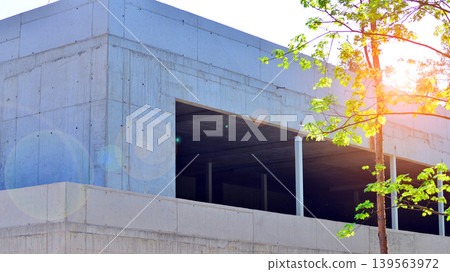 An abandoned concrete building under construction surrounded by a forest. An unfinished two-story modernist structure. An abandoned concrete building under construction surrounded by a forest. An unfinished two-story modernist structure. 139563972