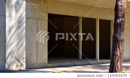 An abandoned concrete building under construction surrounded by a forest. An unfinished two-story modernist structure. An abandoned concrete building under construction surrounded by a forest. An unfinished two-story modernist structure. 139563974