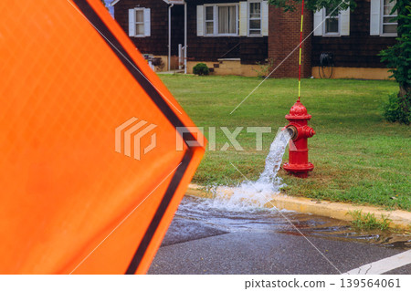 Water flows from fire hydrant leak on quiet street near residential homes Water flows from fire hydrant leak on quiet street near residential homes 139564061