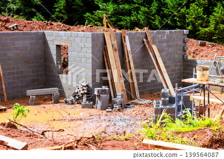 Construction site brick wall partially built with materials scattered around Construction site brick wall partially built with materials scattered around 139564087
