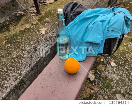 Glass Water Bottle and Fresh Orange on Outdoor Bench Glass Water Bottle and Fresh Orange on Outdoor Bench 139564214