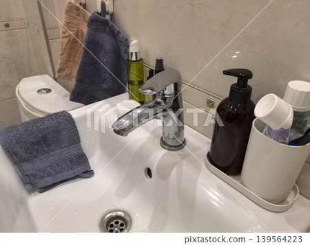 Close-Up of Bathroom Faucet with Soap Dispenser and Towel Close-Up of Bathroom Faucet with Soap Dispenser and Towel 139564223