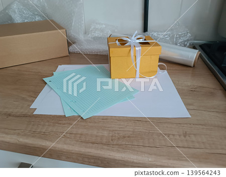Yellow Gift Box with Ribbon on Wrapping Table 139564243