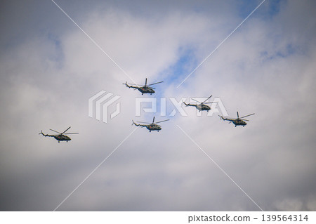 Helicopter squadron flying in coordinated pattern above overcast skies Helicopter squadron flying in coordinated pattern above overcast skies 139564314