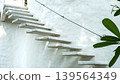 Modern white cantilever concrete stairs on a textured white wall 139564349