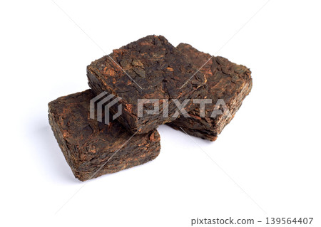 Black pu-erh Chinese tea. Pressed tiles of fermented black tea isolated on white background. Black pu-erh Chinese tea. Pressed tiles of fermented black tea isolated on white background. 139564407