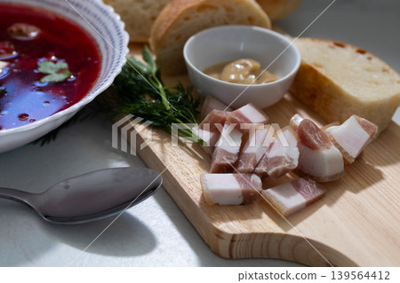 Bowl of traditional borscht soup with sour cream bacon and dill garnish. Eastern European beet soup in rustic presentation. Ukrainian cuisine classic for hearty meals and cultural dining. Bowl of traditional borscht soup with sour cream bacon and dill garnish. Eastern European beet soup in rustic presentation. Ukrainian cuisine classic for hearty meals and cultural dining. 139564412