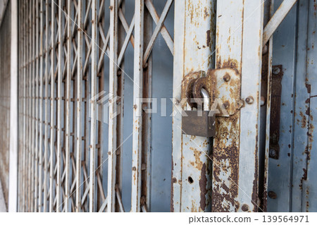 Vintage Folding Metal Gate and Padlock Security on Old Shopfront 139564971