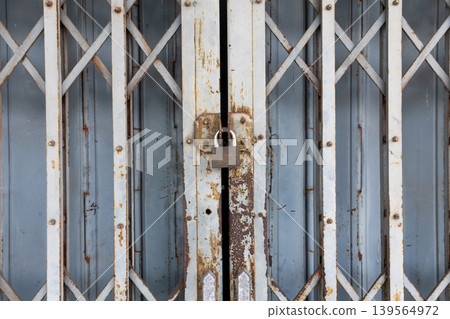 Vintage Folding Metal Gate and Padlock Security on Old Building Vintage Folding Metal Gate and Padlock Security on Old Building 139564972