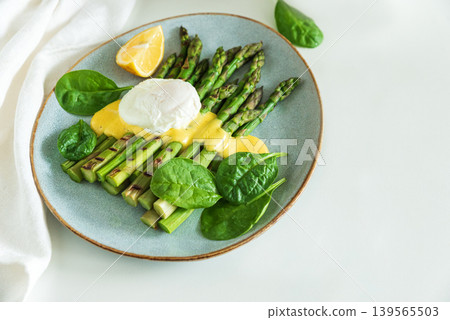 Poached egg with grilled asparagus, spinach, and hollandaise sauce 139565503