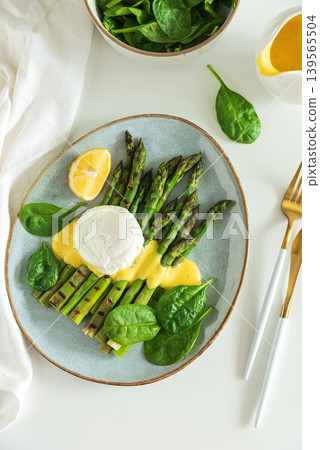 Poached egg with grilled asparagus, spinach, and hollandaise sauce 139565504