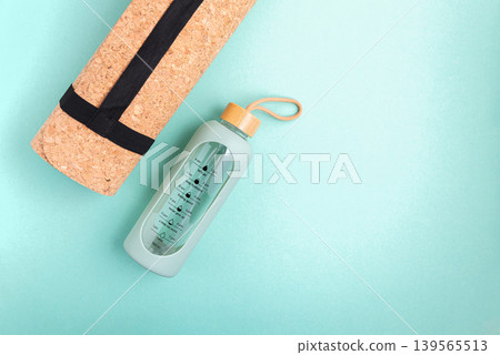 Yoga mat and water bottle on a blue background. Yoga mat and water bottle on a blue background. 139565513