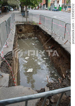 The hole in the road was created to repair underground utilities. 139565532