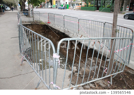 The hole in the road was created to repair underground utilities. 139565546