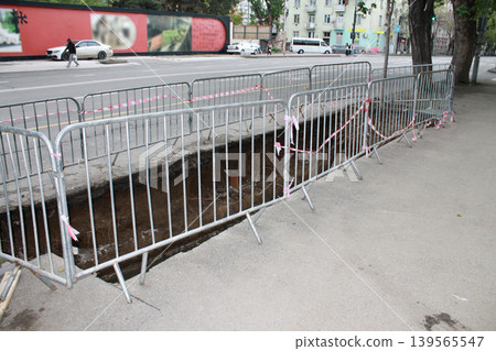 The hole in the road was created to repair underground utilities. 139565547