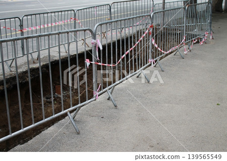 The hole in the road was created to repair underground utilities. The hole in the road was created to repair underground utilities. 139565549
