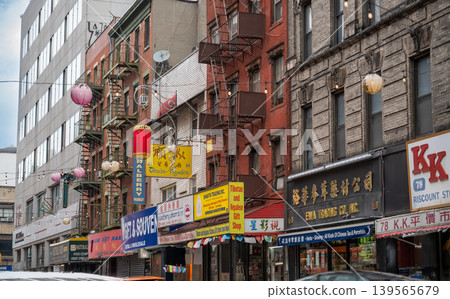 New york, usa august 17,2024. Row of historic mixed use buildings with shops, fire escapes and red lanterns lining mulberry street in manhattan's chinatown, nyc New york, usa august 17,2024. Row of historic mixed use buildings with shops, fire escapes and red lanterns lining mulberry street in manhattan's chinatown, nyc 139565679