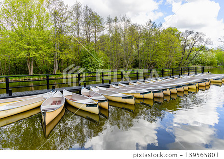 Outdoor recreation area with rowing boats and wooden pier. 139565801