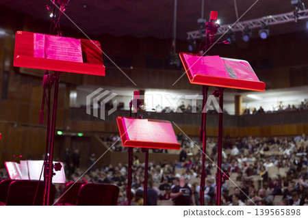Music stands with sheet music on stage before a concert Music stands with sheet music on stage before a concert 139565898