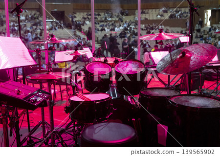 Drum kit on stage before a concert behind a screen Drum kit on stage before a concert behind a screen 139565902