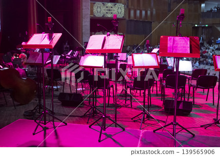 Music stands with sheet music on stage before a concert Music stands with sheet music on stage before a concert 139565906