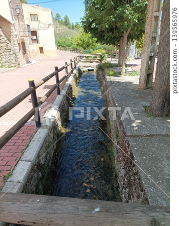 Ancient water canal running through the streets of Fuembellida village, Spain. Ancient water canal running through the streets of Fuembellida village, Spain. 139565976