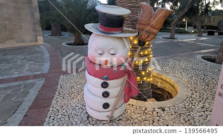 Christmas decoration statue of a sleeping snowman in a park 139566495