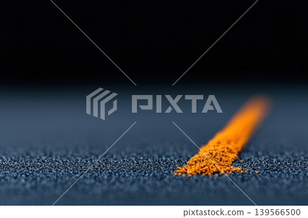 Golden line of turmeric powder on dark surface creating a striking contrast Golden line of turmeric powder on dark surface creating a striking contrast 139566500