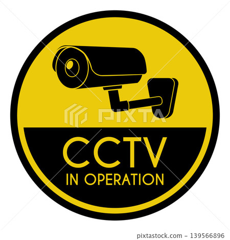 A video camera on a yellow round warning sign with the text "CCTV in Operation." A video camera on a yellow round warning sign with the text "CCTV in Operation." 139566896