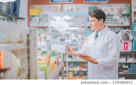 Pharmacist checking Checks Inventory of Medicine, Drugs, Vitamins with tablet and checking patient's prescription in modern pharmacy Pharmacist checking Checks Inventory of Medicine, Drugs, Vitamins with tablet and checking patient's prescription in modern pharmacy 139566952