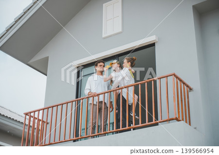 Happy family standing together on balcony of new home enjoying quality time Happy family standing together on balcony of new home enjoying quality time 139566954