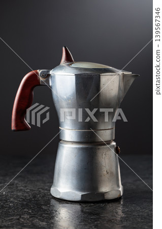 A classic Italian aluminium moka pot on a black background. A classic Italian aluminium moka pot on a black background. 139567346