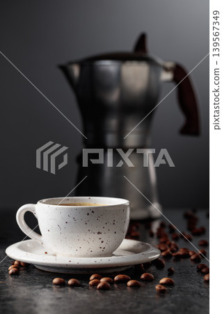 Cup of espresso and classic Italian aluminium moka pot on a black background. Cup of espresso and classic Italian aluminium moka pot on a black background. 139567349