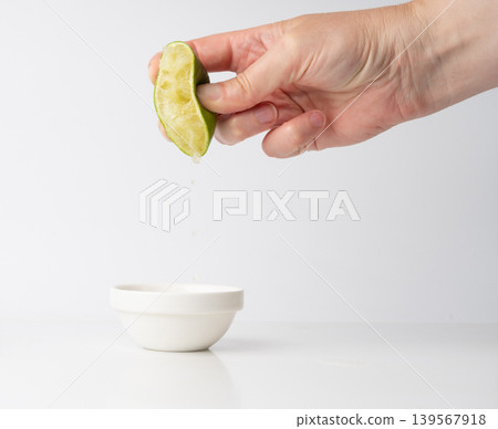Squeezed lime isolated, squeezed out half green lemon on white background, burnout symbol Squeezed lime isolated, squeezed out half green lemon on white background, burnout symbol 139567918