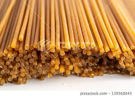 Raw wholegrain brown spaghetti macro texture, dry spagetti pattern Raw wholegrain brown spaghetti macro texture, dry spagetti pattern 139568045