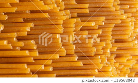 Raw wholegrain brown spaghetti macro texture, dry spagetti pattern Raw wholegrain brown spaghetti macro texture, dry spagetti pattern 139568048