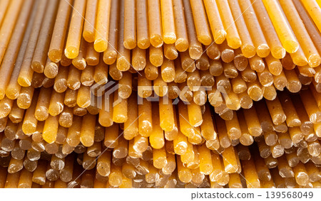 Raw wholegrain brown spaghetti macro texture, dry spagetti pattern Raw wholegrain brown spaghetti macro texture, dry spagetti pattern 139568049