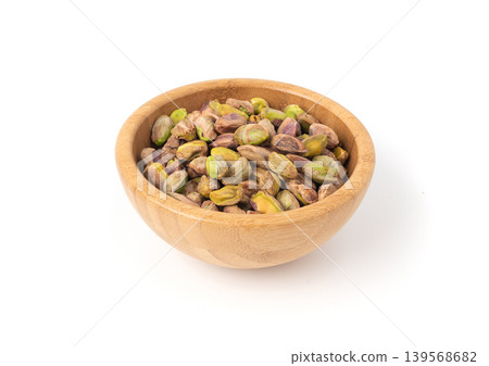 Fried salt pistachio nuts isolated. Baked pistachios pile, roasted green pistache fruits on white Fried salt pistachio nuts isolated. Baked pistachios pile, roasted green pistache fruits on white 139568682