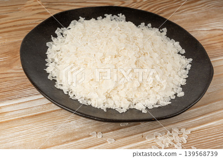 Raw flattened rice. Dry rice flakes or poha, Indian breakfast food Raw flattened rice. Dry rice flakes or poha, Indian breakfast food 139568739