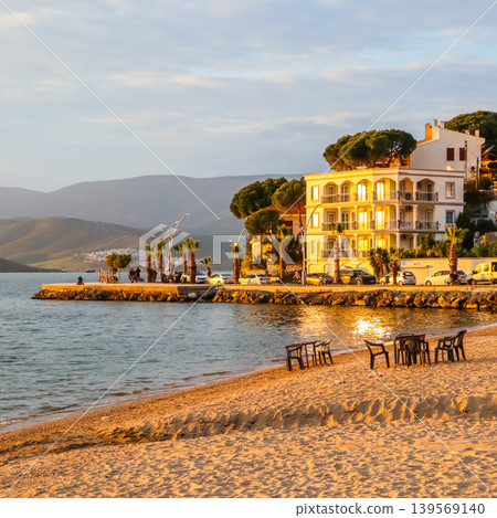 Gulluk, Turkey coastal town view with buildings reflecting golden hour light on beach and water Gulluk, Turkey coastal town view with buildings reflecting golden hour light on beach and water 139569140