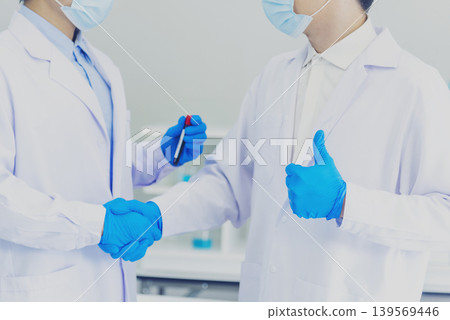 Close up Two asian scientist men team partner shake hands together. Crop Men researcher holding chemistry science tube experiment biotech sample in laboratory. Close up hand corporate partnership Close up Two asian scientist men team partner shake hands together. Crop Men researcher holding chemistry science tube experiment biotech sample in laboratory. Close up hand corporate partnership 139569446