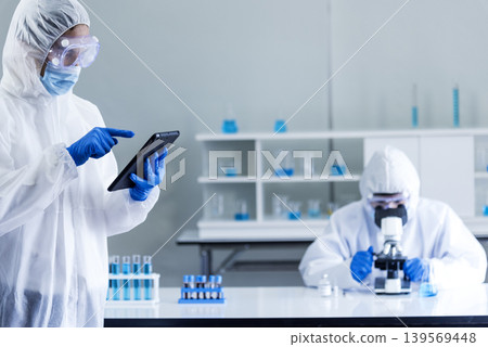 Scientist man look into Microscope research in science laboratory. Asian scientist looking equipment laboratory chemistry labs. Covid-19 coronavirus biochemistry research experiment vaccine concept 139569448