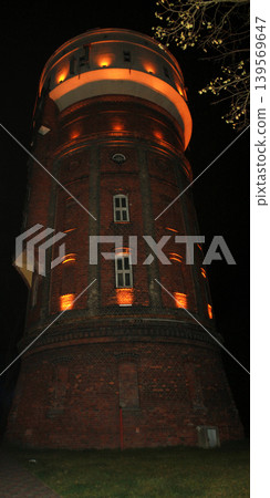 an ancient water tower illuminated by light at night an ancient water tower illuminated by light at night 139569647