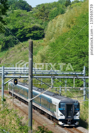 在晴朗的天空下，E257系列列車行駛在東海道本線上。 139569739