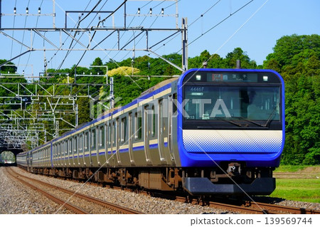 E235 series train running on the Sobu Main Line under a clear blue sky 139569744