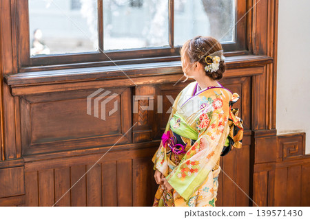 一位身穿振袖和服的 20 歲女子凝視著一棟復古的西式古董豪宅/工作室的窗外。 一位身穿振袖和服的 20 歲女子凝視著一棟復古的西式古董豪宅/工作室的窗外。 139571430