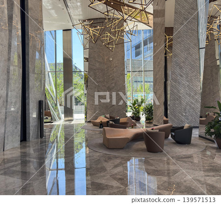 Luxury lobby with geometric gold chandeliers and sculptural sofas. Luxury lobby with geometric gold chandeliers and sculptural sofas. 139571513